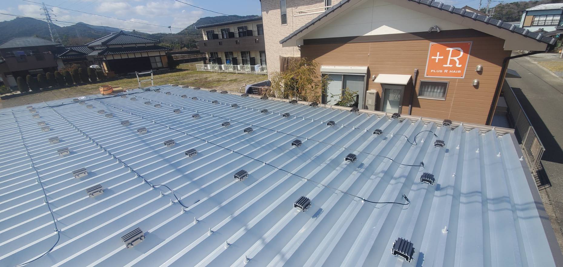 カーポートの屋根に掴み金具を設置して太陽光パネルを載せます。